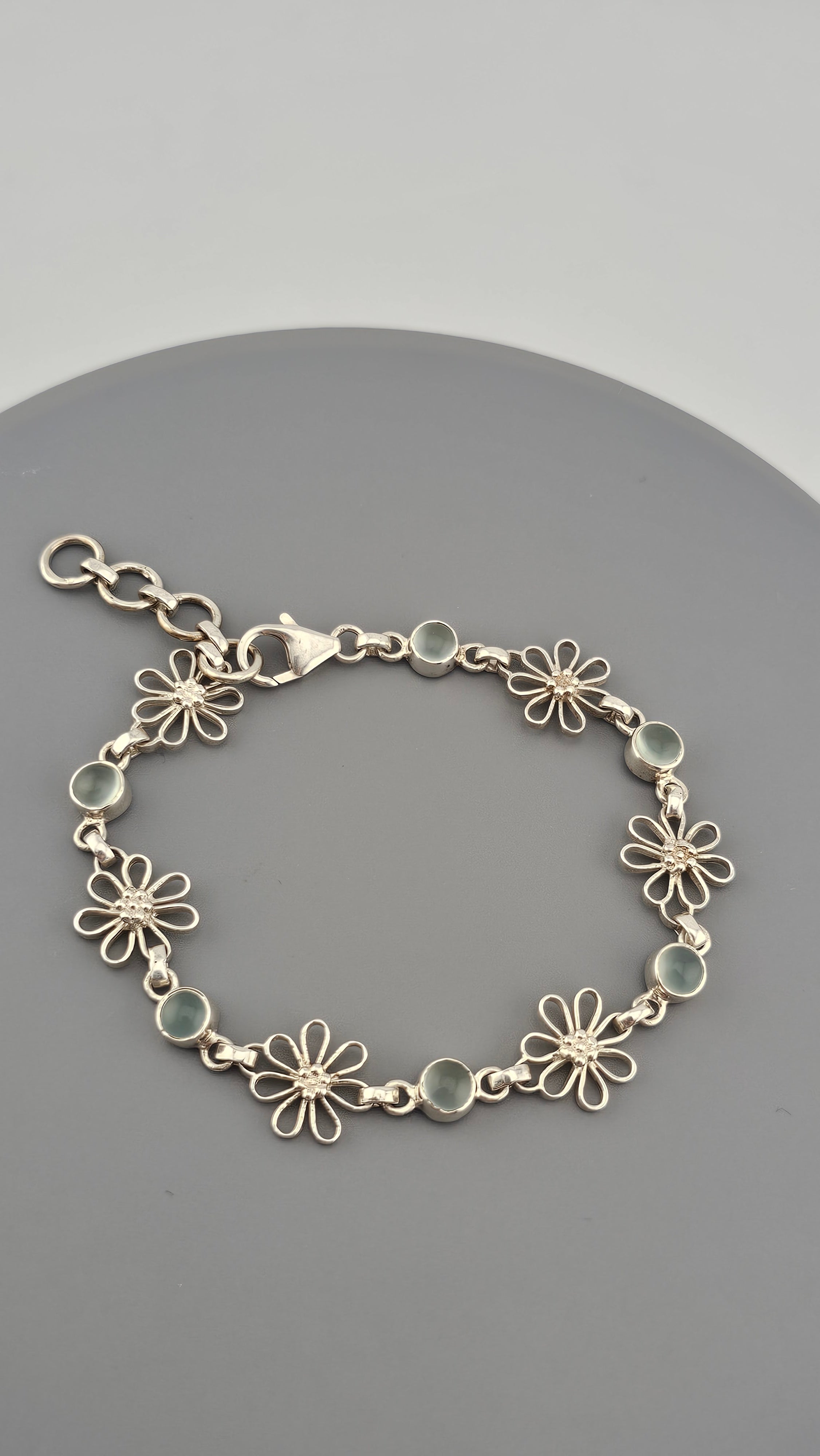 925 sterling silver daisy link bracelet featuring light blue, round cabochon aquamarine