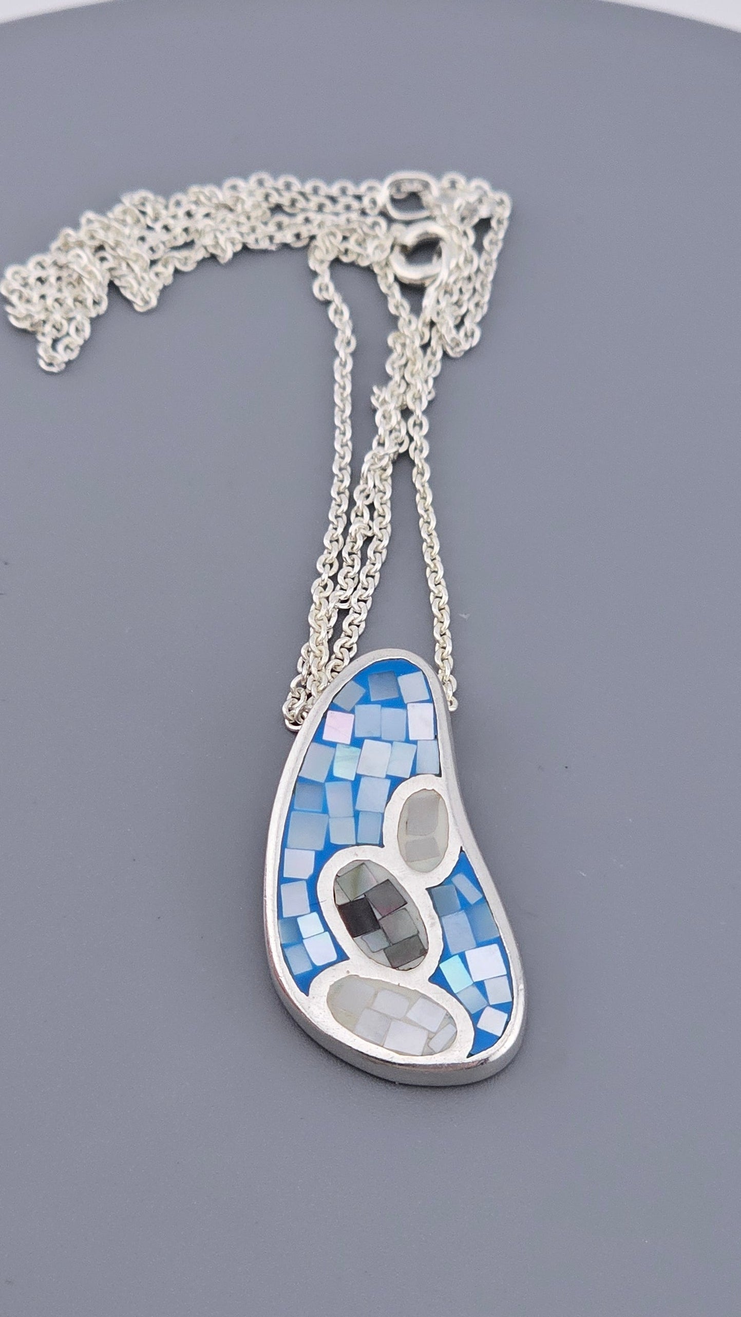 Jewelry with a blue and white pendant on a gray background