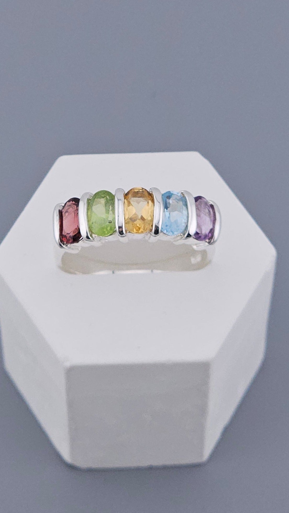 Hexagonal concrete wall hook with colorful rings on a gray background