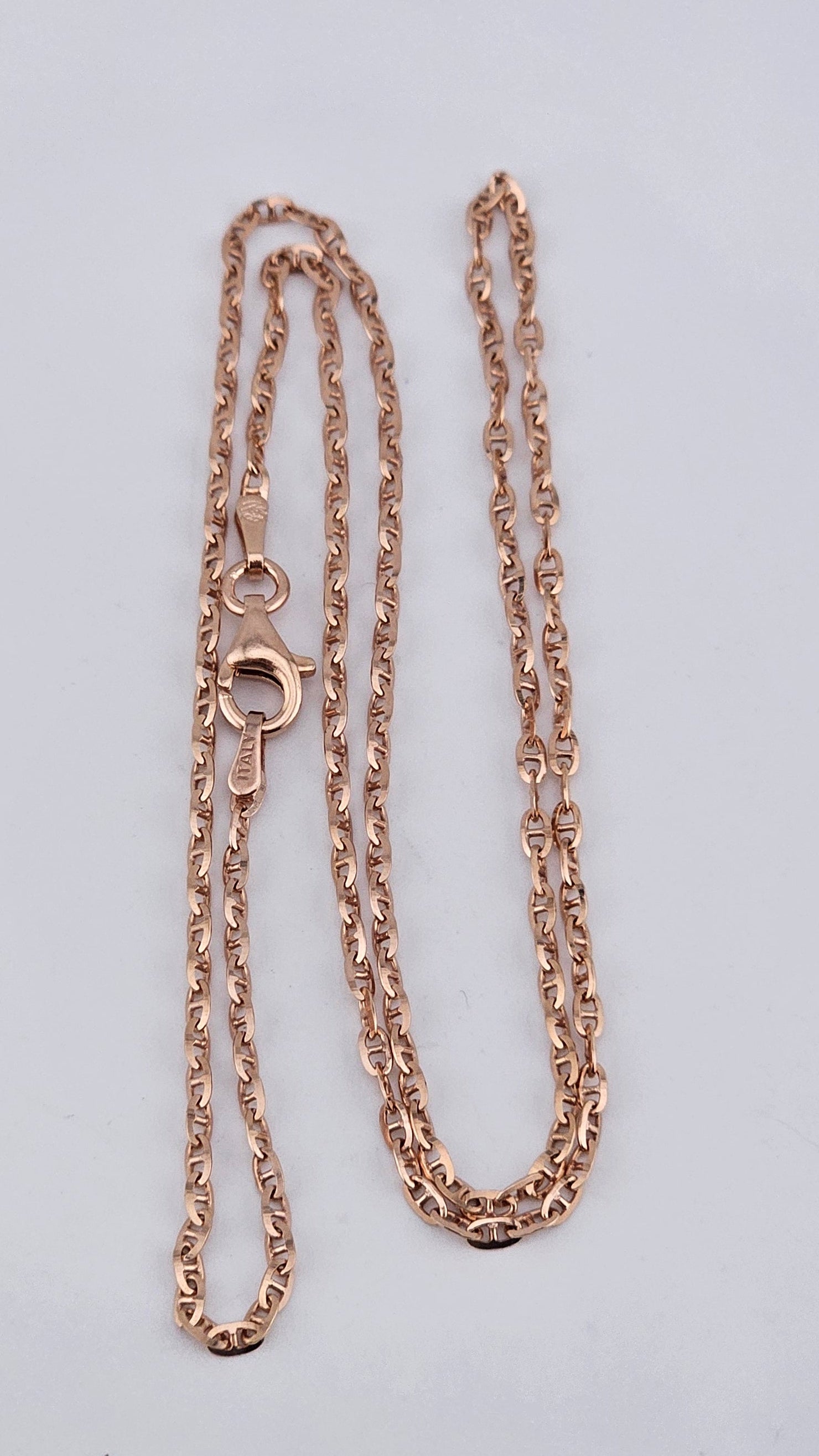 Rose gold necklace on a light gray background