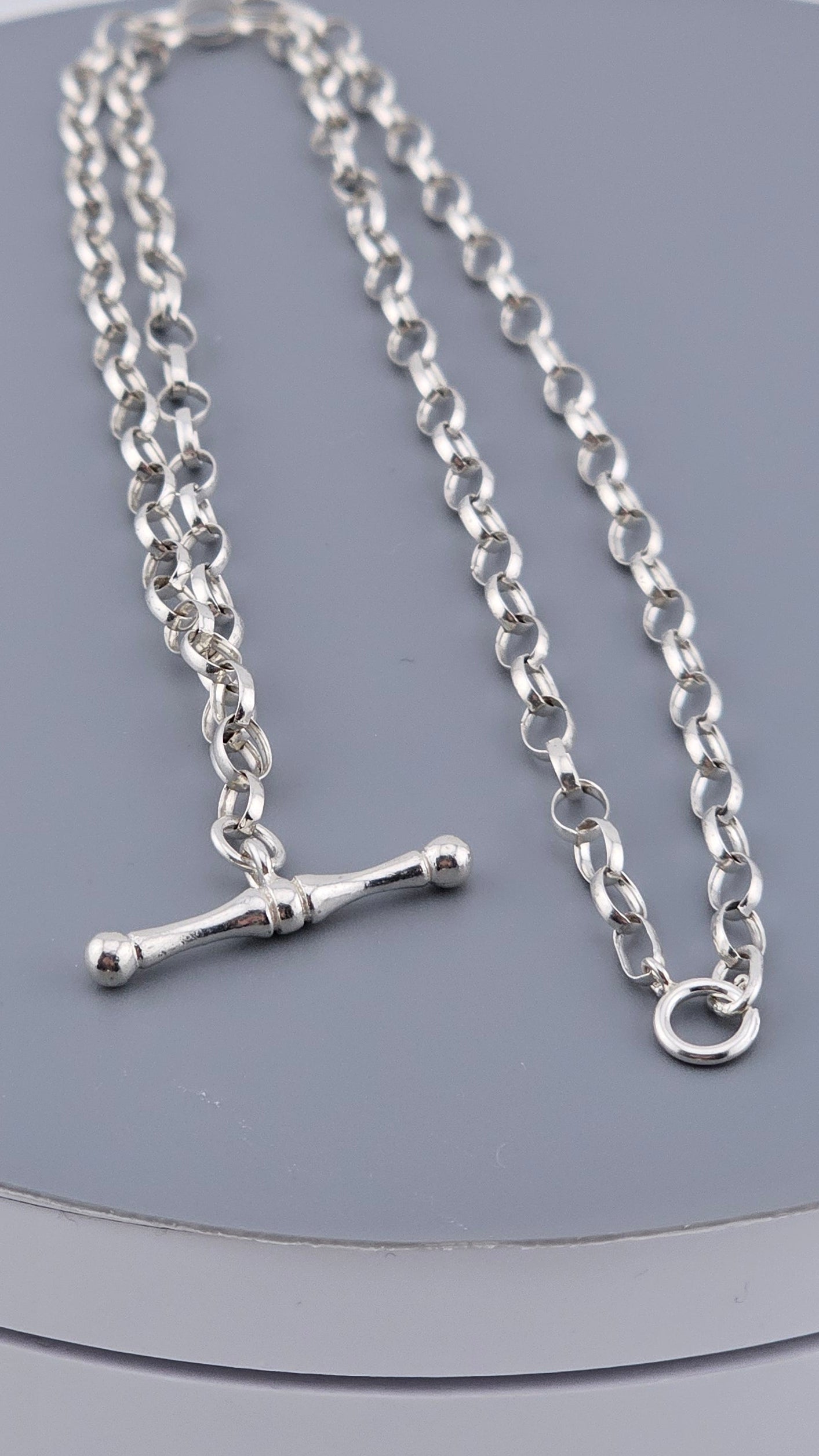 Silver chain necklace on a gray background