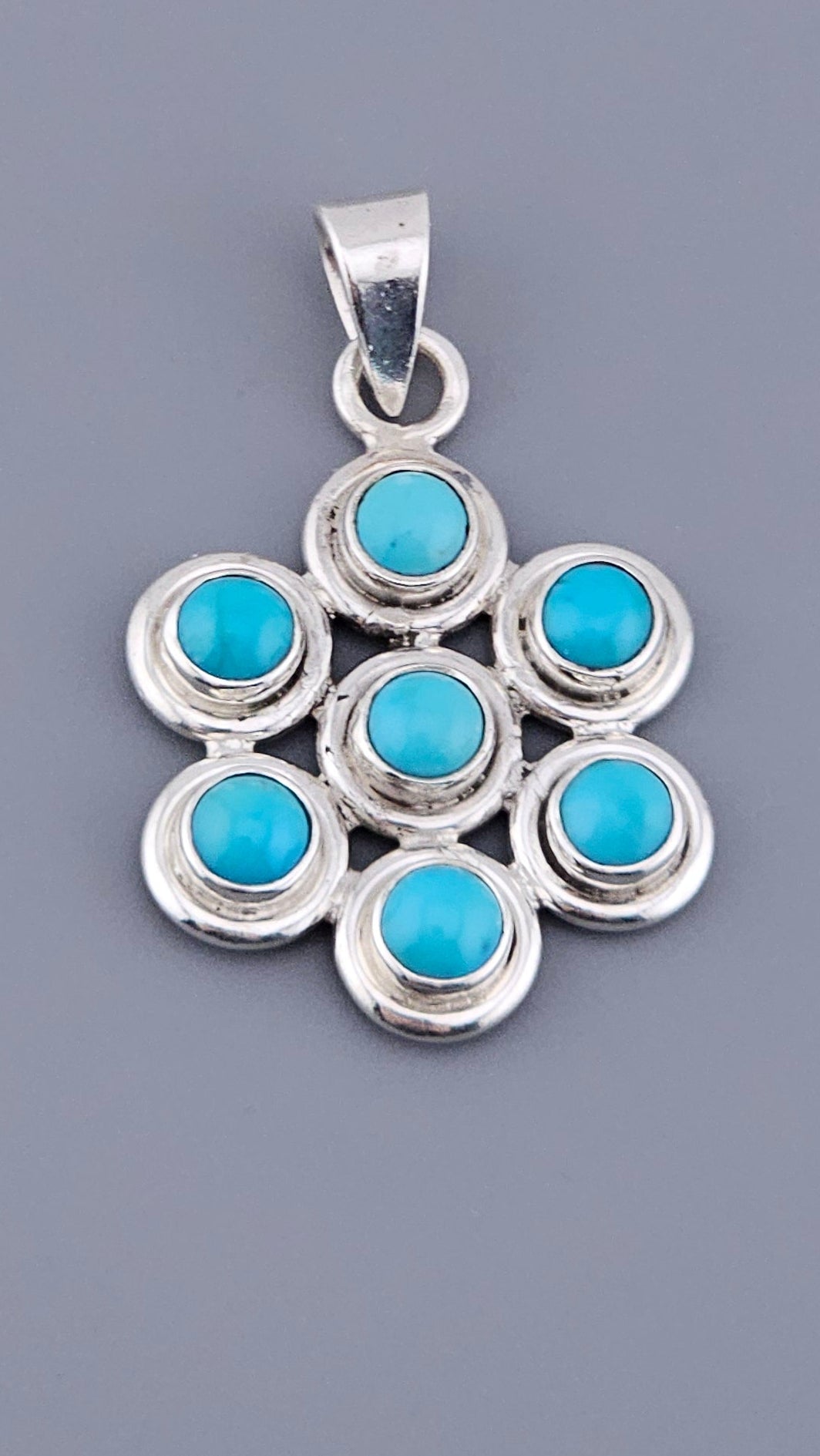 Vintage 925 Sterling Silver Turquoise Multi-Stone Pendant featuring 7 round stones set in fine silver 925 flower geometry, ready to be attached to your favourite chain. Shop now at Jewel Standard House!
